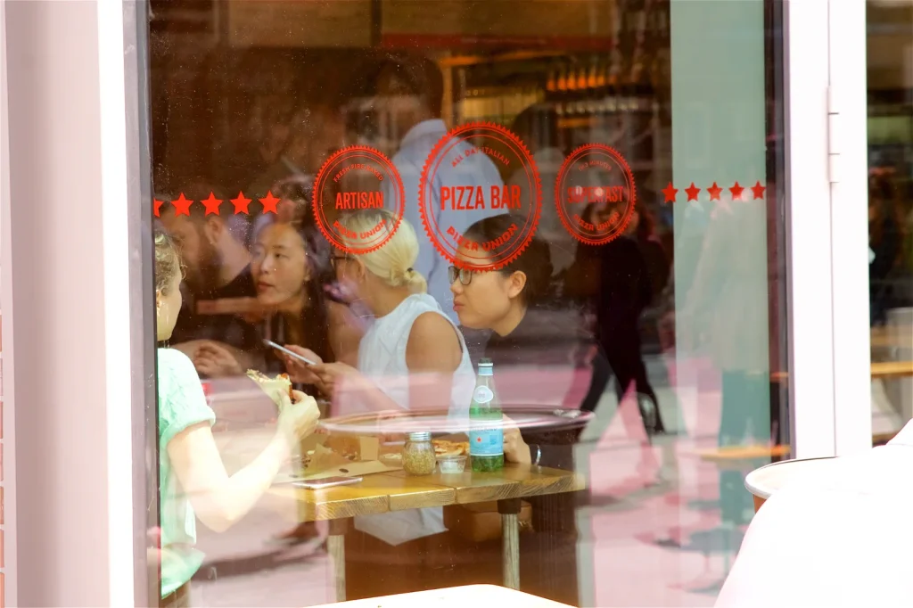 Guests eating pizza in the window at Pizza Union Hoxton