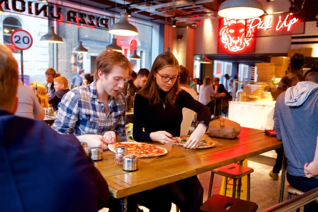 Two guests sharing pizza at Pizza Union Aldgate